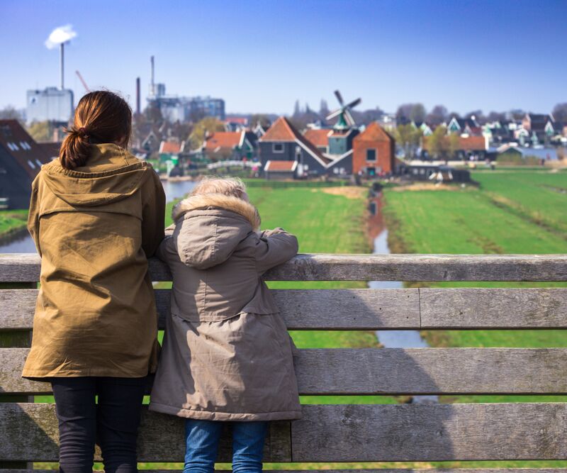 Twee mensen kijken naar skyline met huizen en molen