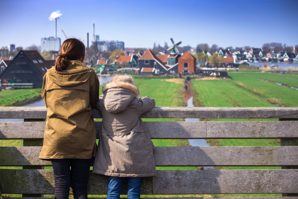 Twee mensen kijken naar skyline met huizen en molen